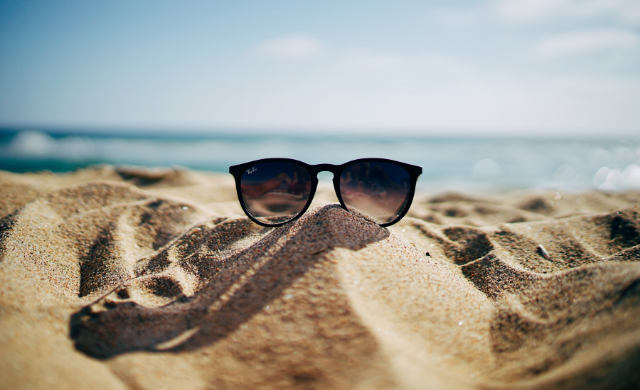 A pair of sunglasses on some sand