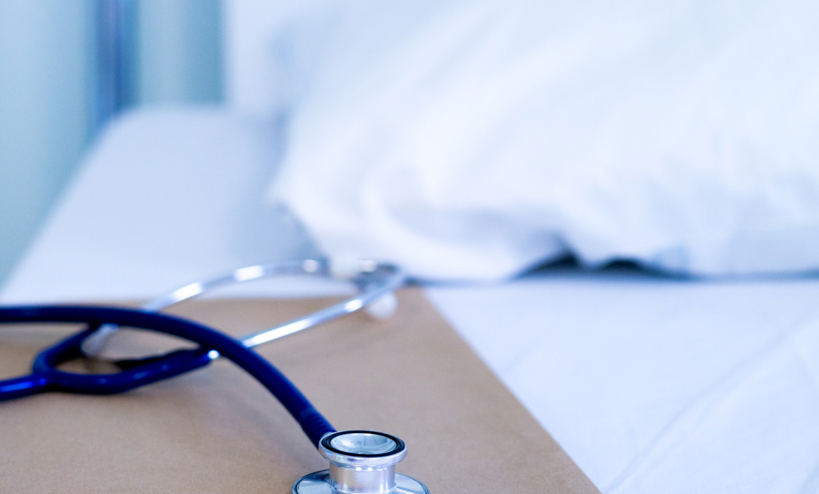 hospital bed and table with stethoscope.