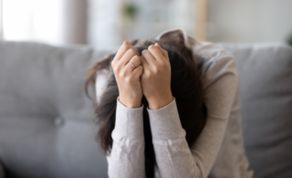 a woman holding her head in her hands and looking stressed